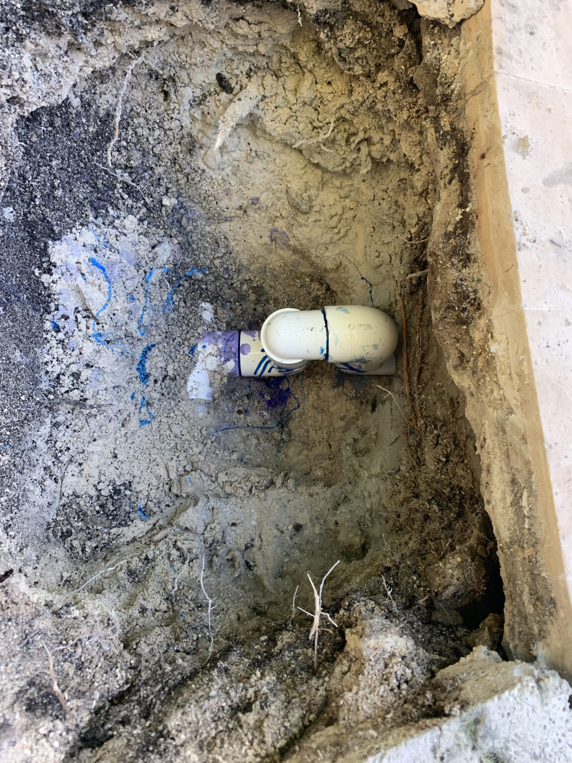 Excavated pool plumbing connection during swimming pool repair