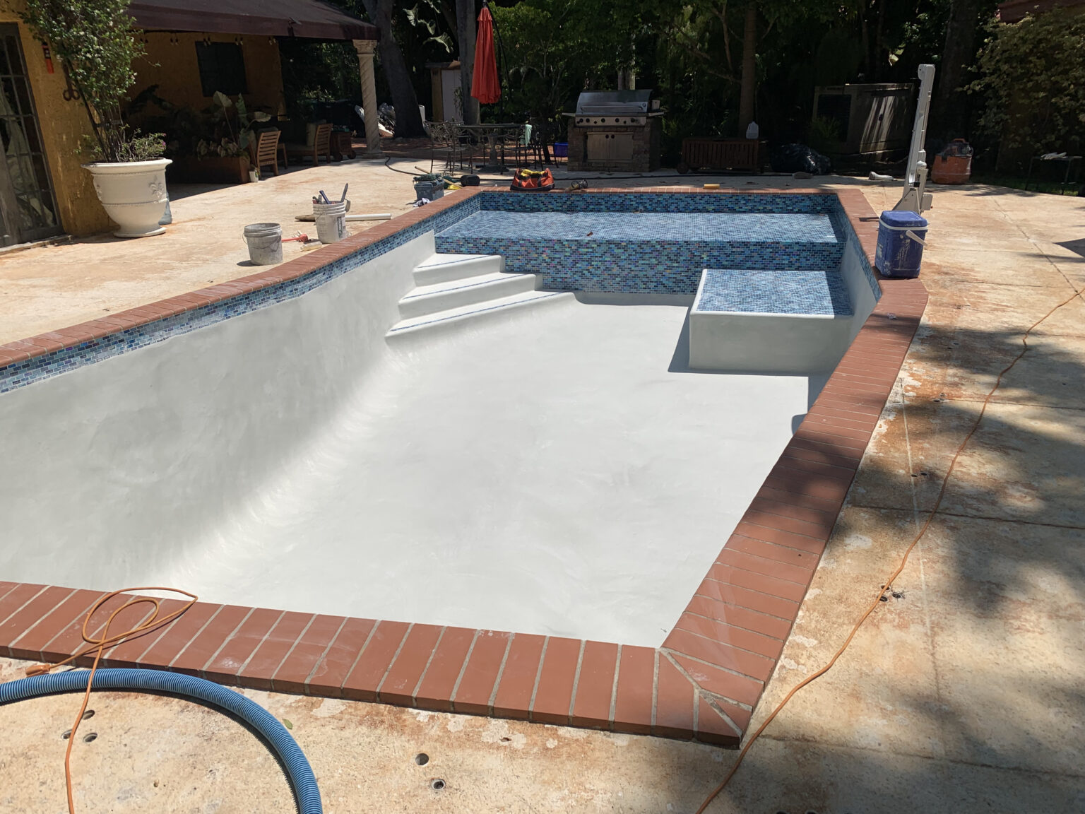 Pool renovation showing newly tiled interior and finished steps